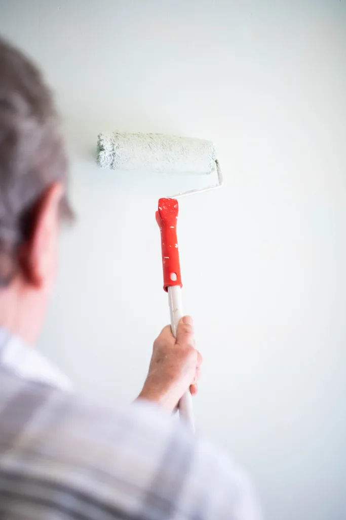 male hand painting wall with paint roller. Painting apartment, r Painting house time
